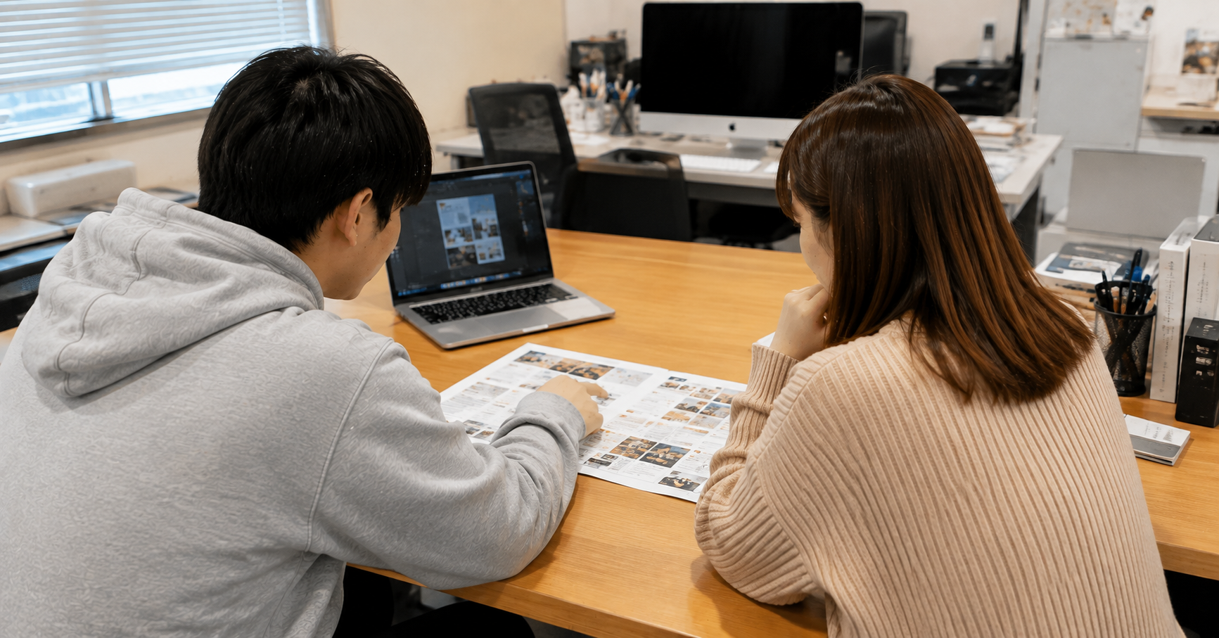 スタッフと制作物を囲んで打ち合わせする様子
